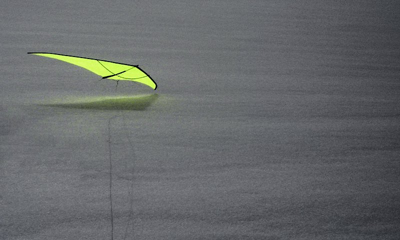 A neon-yellow kite by night.