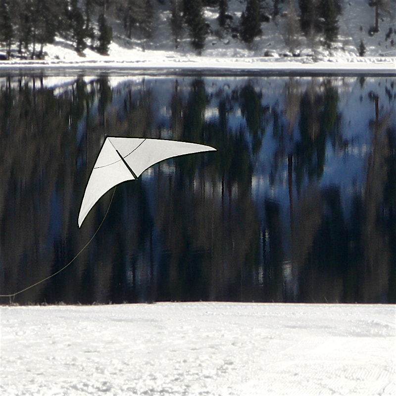a kite gliding over the silvaplana lake.