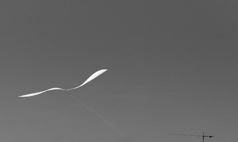 A zero wind kite floating above the stadium wasteland.