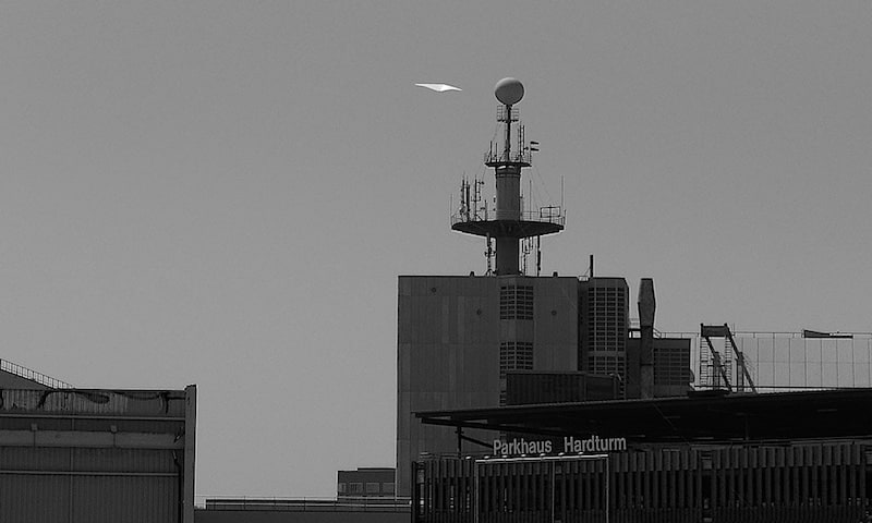 A white kite in some wind high above Zurich.