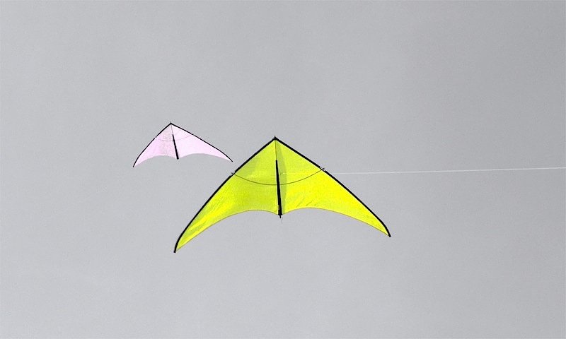 With wind: two kites on long wires.
