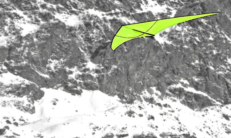 The large kite is floating in the rocks, neon yellow.